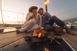 riche Senior couple toasting champagne on sailboat vacation - Happy ma