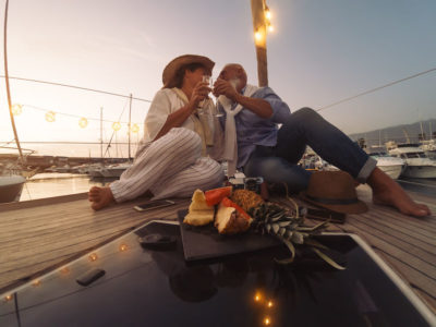 riche Senior couple toasting champagne on sailboat vacation - Happy ma