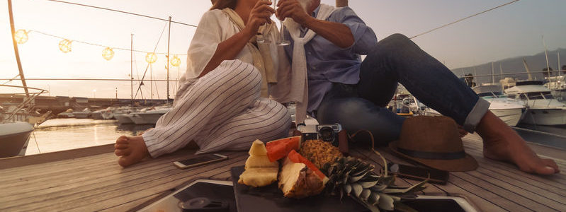 riche Senior couple toasting champagne on sailboat vacation - Happy ma